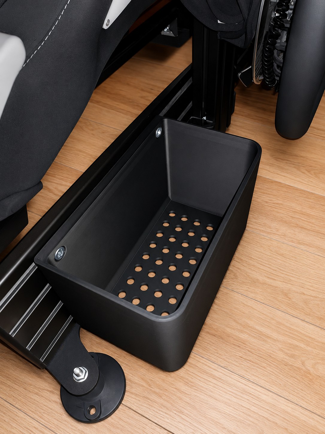 Boîte de rangement installée sous un châssis simracing